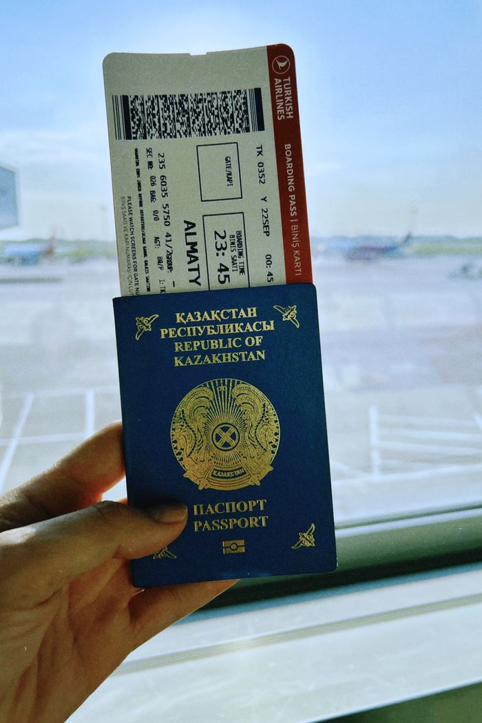 Airline ticket with euro coins and smartphone displaying flight details.